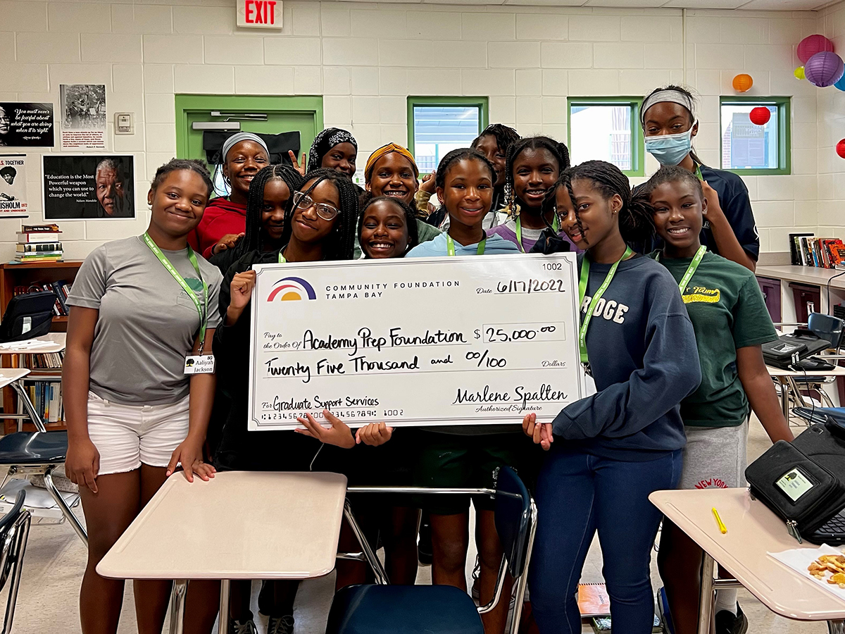 Academy Prep, students holding a big check
