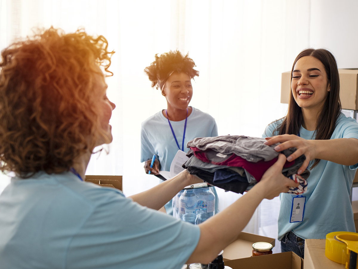 Three women handing out clothing
